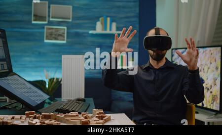 Modern architect using vr glasses for building model and construction layout with virtual reality. Man engineer working with headset for maquette and architectural development. Stock Photo