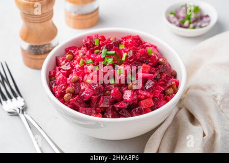 Beetroot salad, vinaigrette with vegetables close-up on a gray background. Traditional Russian salad. Side view. Stock Photo