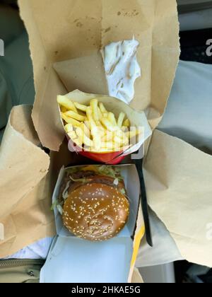 Basel, Switzerland - Dec 20, 2021: Vertical image of french fries and delicious hamburger bought in Basel McDonald's restaurant Stock Photo