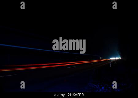 Red and white lights from passing cars. Night highway. Stock Photo