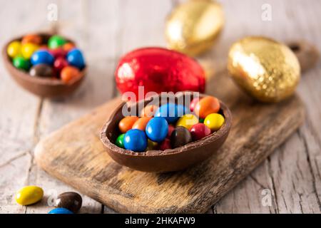 Colorful chocolate Easter eggs on wooden table Stock Photo