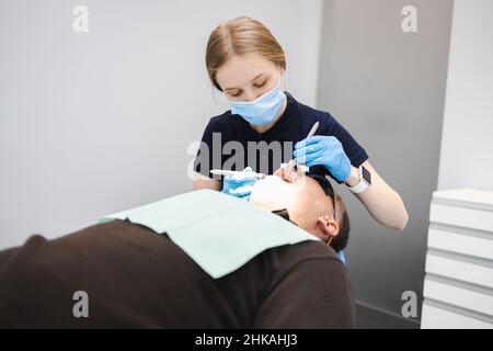 Female doctor dentist examines the teeth of a male patient Stock Photo