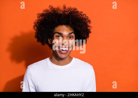 Photo of young cheerful man good mood comic humor laugh chevelure isolated over orange color background Stock Photo