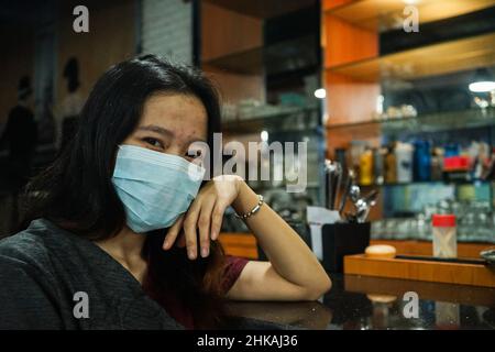 Makassar, South Sulawesi, Indonesia. 3rd Feb, 2022. Portrait of a female cafe employee in Makassar City, Indonesia wearing a mask. The use of masks in Indonesia continues to be encouraged to prevent transmission of the Omicron type of corona virus. (Credit Image: © Herwin Bahar/ZUMA Press Wire) Stock Photo