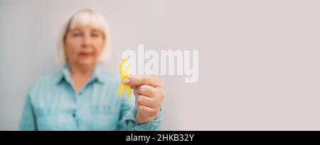 Yellow Ribbon for supporting people living and illness. Childhood cancer Awareness month. Suicide prevention day. Children healthcare and World cancer Stock Photo