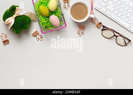 Top view of the desktop. Cup of coffee glasses keyboard with easter decorations. Flat lay copy space Stock Photo