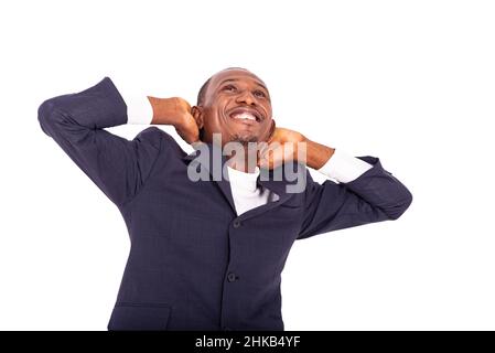happy, relaxed adult businessman putting hands behind head and looking upwards smiling. Stock Photo