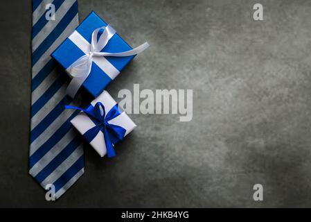 Happy Father's Day. Top view of gifts boxes, necktie and copy space over gray background. Father's Day celebration concept Stock Photo
