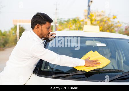 Cab driver cleaning car before starting work - concept of professional occupation, self employment and small business Stock Photo