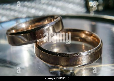 scratched wedding rings on a shiny metal surface. selective focus Stock Photo