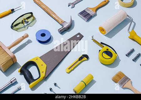Flat lay still life of a large selection of assorted workshop tools and hardware arranged diagonally over blue Stock Photo