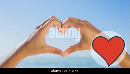 Digital composite image of caucasian female cropped hands making heart shape against blue sky Stock Photo