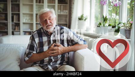 Caucasian senior man with eyes closed and hands on chest suffering from heart pain Stock Photo