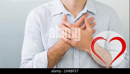Midsection of caucasian young man with hands on chest suffering from heart pain Stock Photo