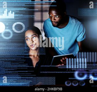 Reading the data over again. Shot of two programmers working together on a computer code at night. Stock Photo