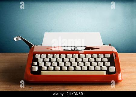 A typewriter whith a sheet of paper on a wooden desk Stock Photo