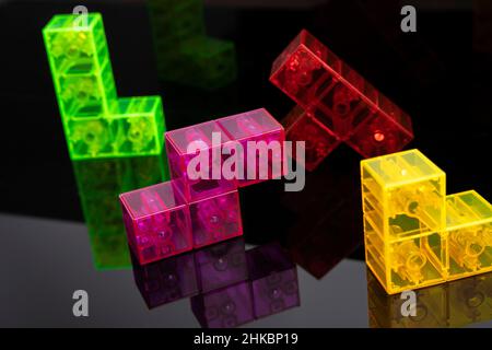 colored tetris figures on glossy black glass, space for copying. The concept of creative, logical thinking, teamwork Stock Photo