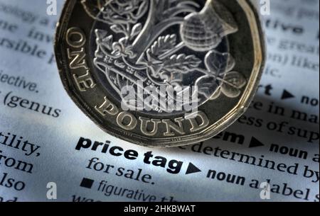 DICTIONARY DEFINITION OF WORD PRICE TAG WITH ONE POUND COIN RE INFLATION THE ECONOMY COST OF LIVING SHOPPING ETC UK Stock Photo
