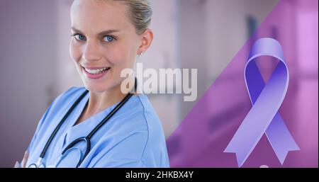 Digital composite image of blue cancer ribbon and smiling caucasian young female doctor Stock Photo