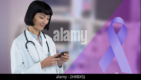 Digital composite image of blue ribbon and smiling asian young female doctor using smart phone Stock Photo