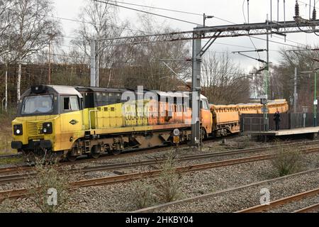 Colas Rail liveried Class 70 number 70815 working a Mountsorrel Tarmac to Carlisle New Yard ballast train joins the WCML at Lichfield Trent Valley Stock Photo