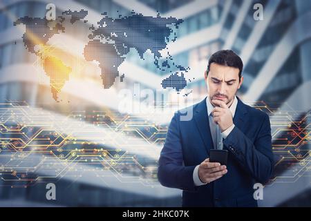 Business planning and modern technology concepts as pensive businessman uses a smartphone for internet trading and metaverse access. Global network, w Stock Photo