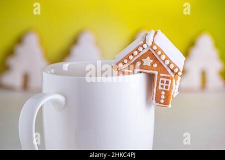 Gingerbread huts and a cup of milk, close-up view. Christmas celebration concept Stock Photo
