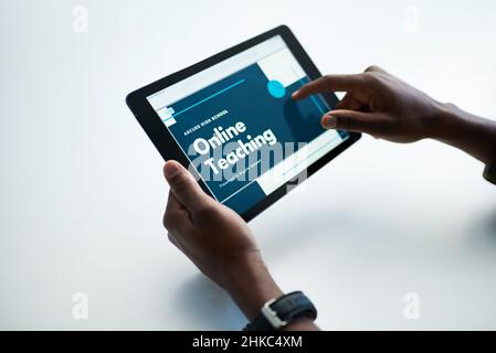 Go the distance, get that degree. Cropped shot of a man using a digital tablet to have an online lesson. Stock Photo