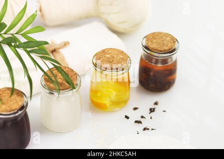 Fermented beauty care. Wellness composition with hande made rice water, green tea water, lemon water and cosmetic accessories on a white table. Natura Stock Photo