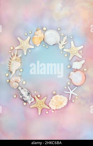 Beautiful seashell wreath with pearls on rainbow coloured sky cloud background. Nature, summer, sea life concept.  Top view, flat lay, copy space. Stock Photo