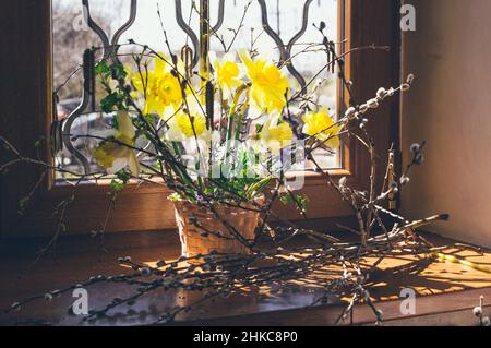 easter spring bouquet of yellow daffodils in basket and willow Stock Photo