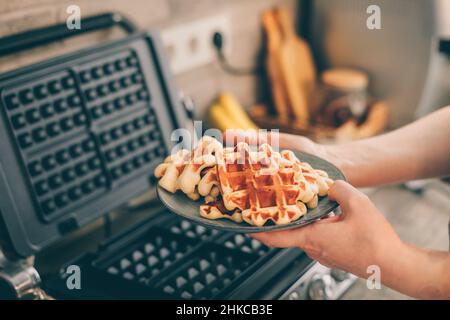 Young woman holding in hands plate with Belgian waffles. Stock Photo