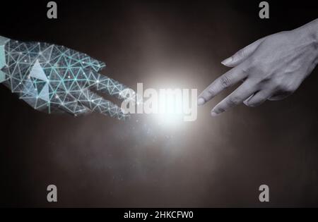Robot and human reaching towards each other Stock Photo