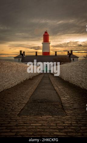 The cobbled pathway to the red and white striped, 23 meter tall,  Souter Lighthouse in Marsden, South Shields as the sun rises Stock Photo