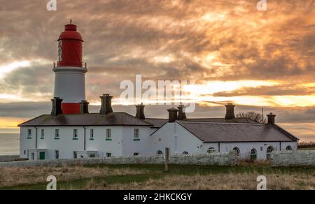 The red and white striped, 23 meter tall,  Souter Lighthouse and the Leas in Marsden, South Shields, England, as the sun rises Stock Photo