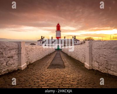 The cobbled pathway to the red and white striped, 23 meter tall,  Souter Lighthouse in Marsden, South Shields as the sun rises Stock Photo