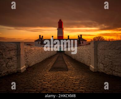 The cobbled pathway to the red and white striped, 23 meter tall,  Souter Lighthouse in Marsden, South Shields as the sun rises Stock Photo