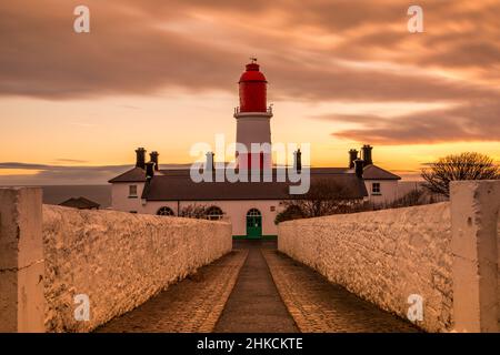 The cobbled pathway to the red and white striped, 23 meter tall,  Souter Lighthouse in Marsden, South Shields as the sun rises Stock Photo