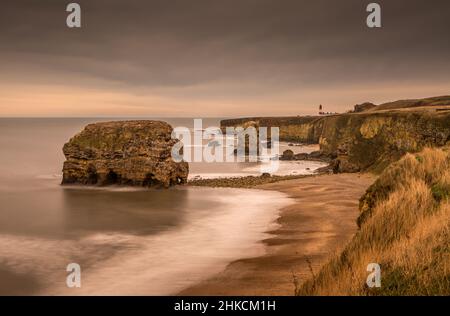 The view along Marsden Bay near Sunderland, of the cliffs and the Sandstone Sea stacks, as the tide comes in Stock Photo