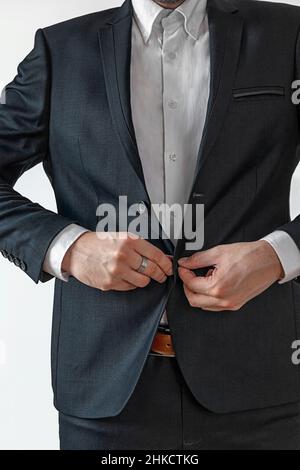 Man in dark suit two buttons, doing button Stock Photo
