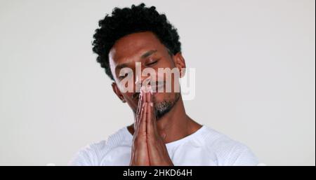 African man feeling hopeful with sign of prayer and faith portrait smiling and charismatic being grateful Stock Photo