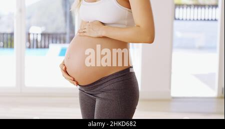 The baby comes first. Cropped shot of an unrecognizable young pregnant woman rubbing her baby bump. Stock Photo