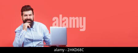 Holding laptop computer.Young businessman using his laptop, pc. Smiling handsome bearded man worker laptop. Happy young man sitting on the floor with Stock Photo