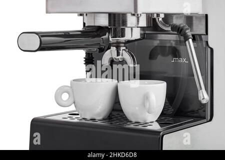 gray stainless steel coffee horn maker with espresso filter holder and steam wand in white ceramic cups 30 ml, professional coffee equipment close-up Stock Photo