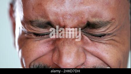 Person close-up eyes closed feeling upset feeling emocional, squinting eyesight Stock Photo