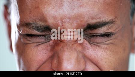 Person close-up eyes closed feeling upset feeling emocional, squinting eyesight Stock Photo