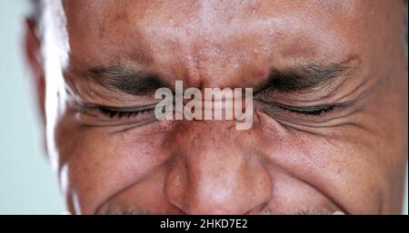 Person close-up eyes closed feeling upset feeling emocional, squinting eyesight Stock Photo