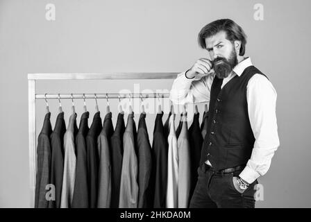 Man picking suit from personal wardrobe, boutique shop concept Stock Photo