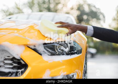 Cropped image of wheel of luxury yellow car in outdoors self-service car  wash, covered with cleaning soap foam Stock Photo - Alamy