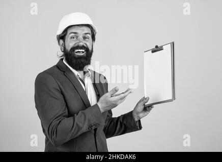 Safety expert. building concept. builder or engineer in hard hat. happy mature architect in helmet making notes. brutal bearded man work on Stock Photo